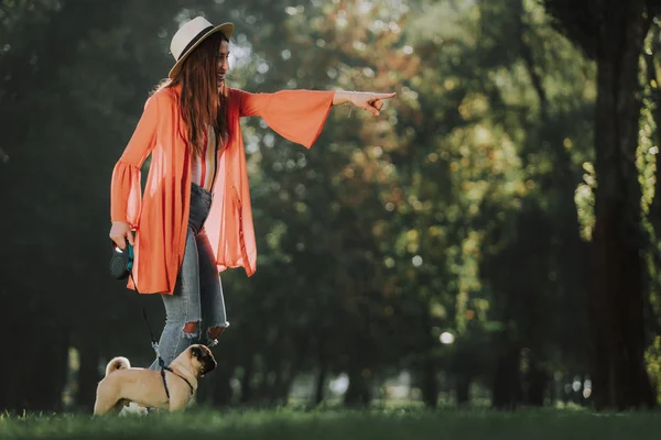 Femme souriante entraîne son animal de compagnie dans le parc — Photo