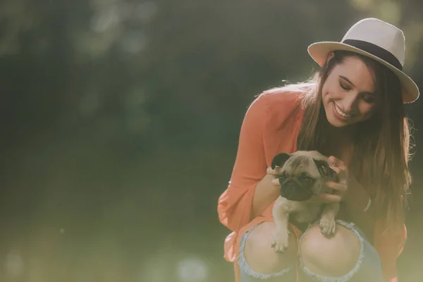 Cheirando bonito mulher está segurando seu cão — Fotografia de Stock
