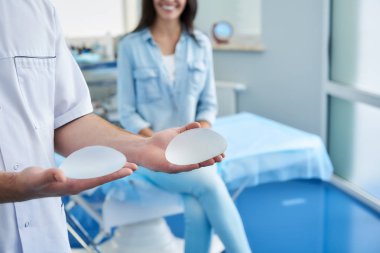 Onun ellerinde silikon tutan cerrah implantlar
