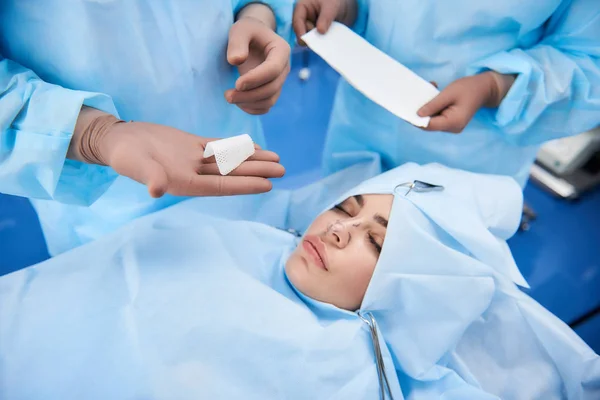Жінка лежить на операційному столі з закритими очима — стокове фото