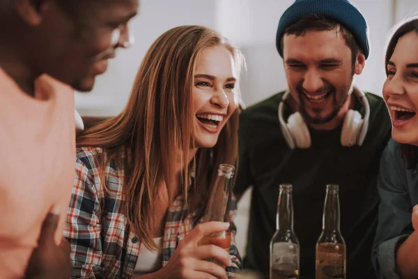 Cheerful young people enjoying drinks and laughing — Stock Photo, Image