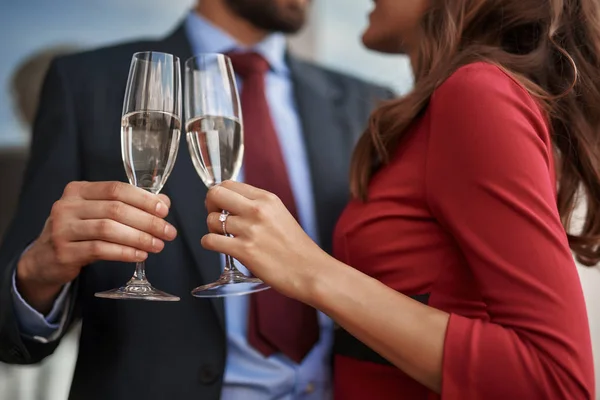 Мужчина и женщина празднуют с бокалами шампанского на открытом воздухе — стоковое фото