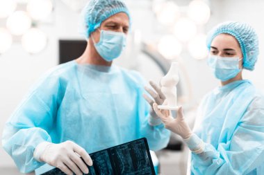 Kendine güvenen doktorlar ona bakarken kemik modeli tartışıyor