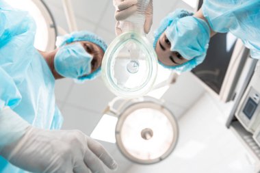 Bottom view of the anesthetic mask and two doctors standing near clipart