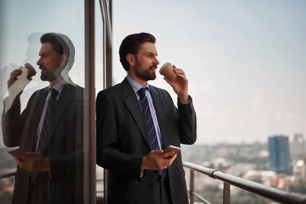 Man in kantoor pak drinken koffie op balkon — Stockfoto