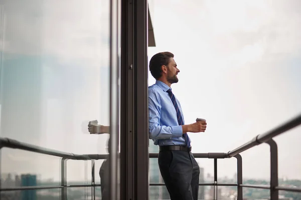 Un trabajador masculino bebiendo café en el balcón de la oficina —  Fotos de Stock