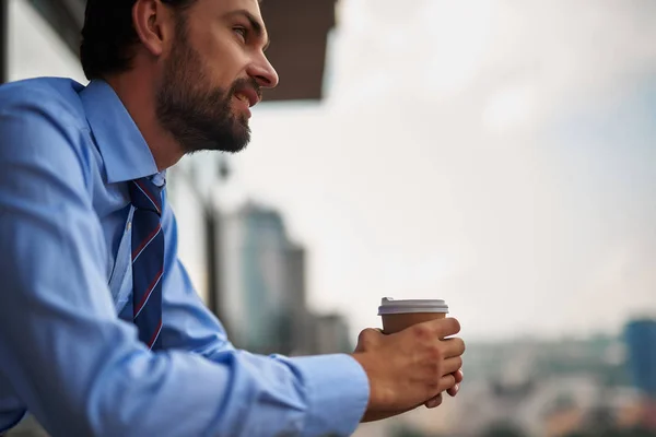 Een mannelijke werknemer drinken koffie op kantoor balkon — Stockfoto