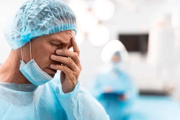 Trauriger Arzt versteckt sein Gesicht nach ermüdender Operation — Stockfoto