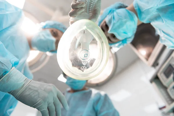 Закрыть анестезиологическую маску и трех докторов вместе — стоковое фото