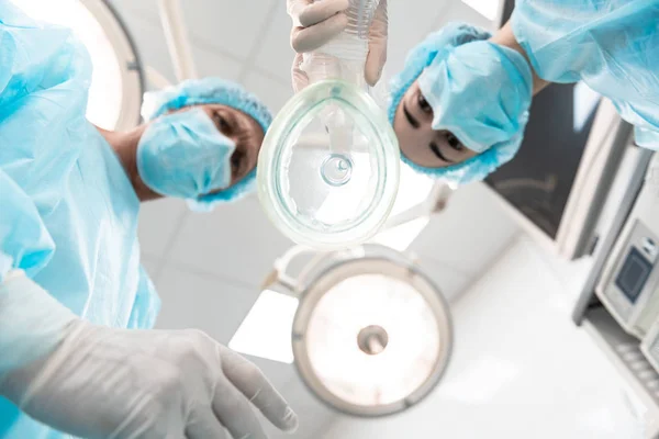 Vue du bas du masque anesthésique et deux médecins debout près — Photo