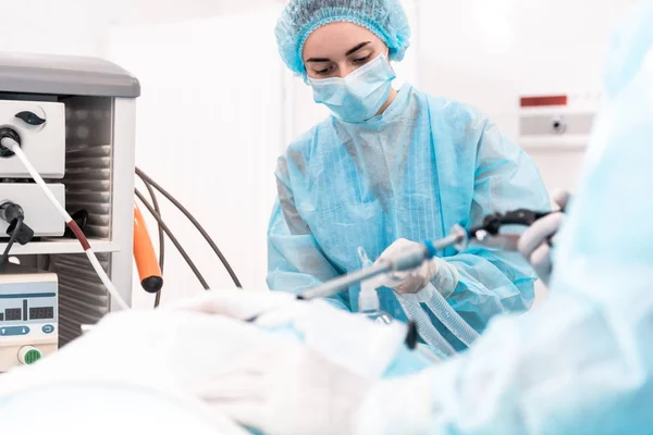 Vorsichtiges medizinisches Personal lehnt sich mit Narkosemaske an den Patienten — Stockfoto