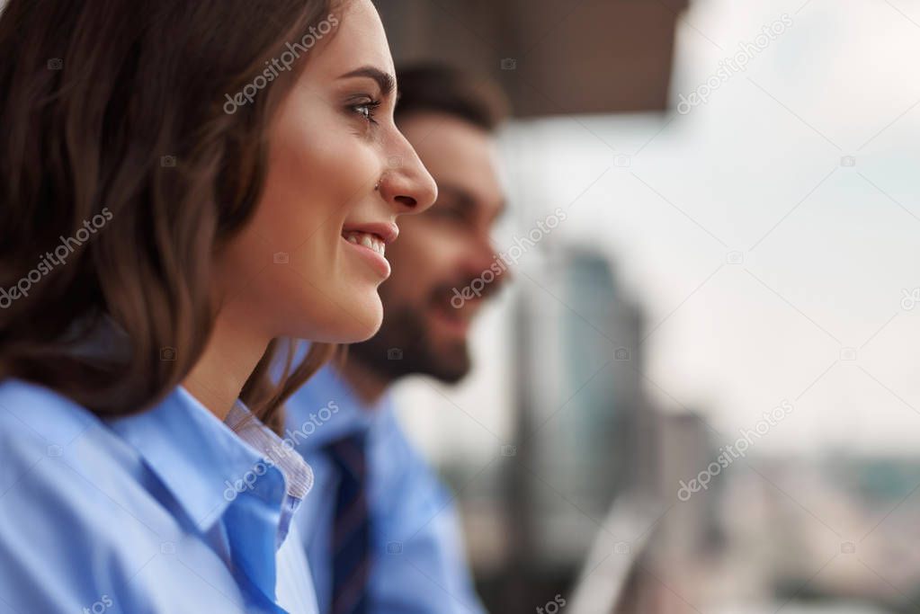 Two colleagues standing on balcony to have break