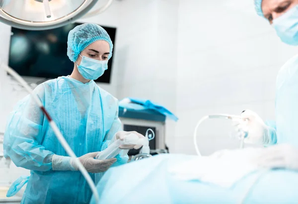 Krankenschwester mit Sauerstoffmaske im Gesicht des Patienten während der Operation — Stockfoto