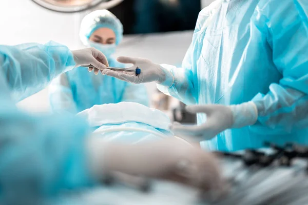 Enfermera asistiendo al cirujano durante la operación quirúrgica — Foto de Stock