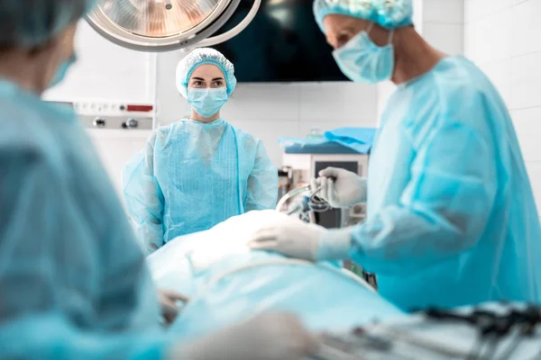 Enfermera mirando al cirujano durante la operación quirúrgica — Foto de Stock