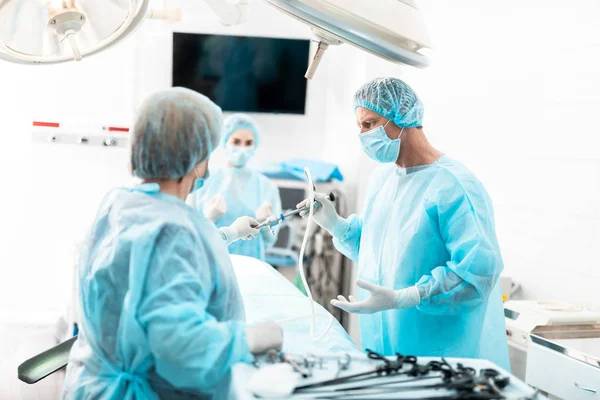 Krankenschwester gibt dem Chirurgen während der Operation ein Laparoskop — Stockfoto