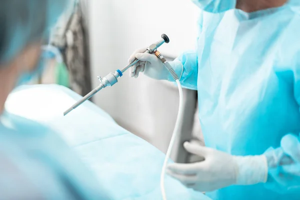 Chirurgien en blouse bleue stérile utilisant un laparoscope pendant l'opération chirurgicale — Photo