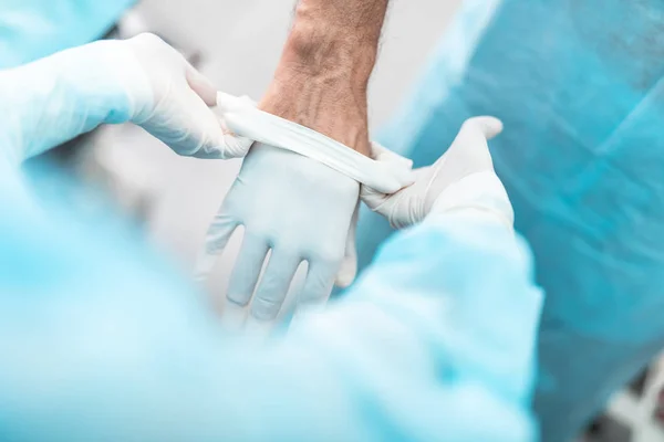 Assistenten hjälper läkare att förbereda för kirurgisk operation — Stockfoto