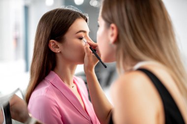 Deneyimli makyaj sanatçısı gölge fırça kullanarak