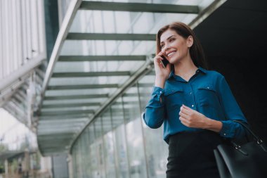 Cep telefonuyla konuşurken gülümseyen güzel kadın