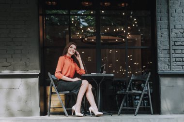 Kafede telefonla konuşurken başarılı iş kadını