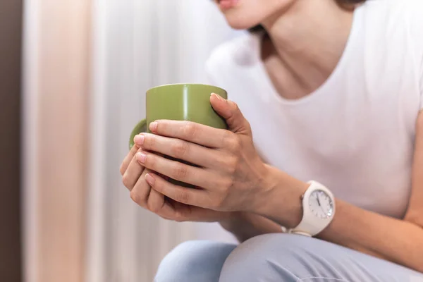 Focus sulla tazza verde nelle braccia femminili — Foto Stock