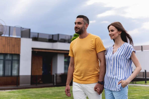 Neşeli çift ayakta açık havada yüzlerinde gülümsemeyle