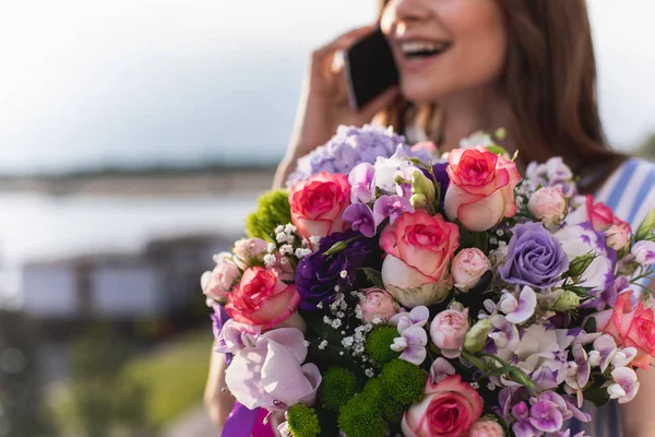 Close-up of various flowers in female hands