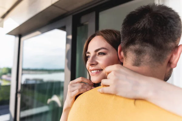 Man knuffelen gelukkig glancing vooruit jonge vrouw — Stockfoto
