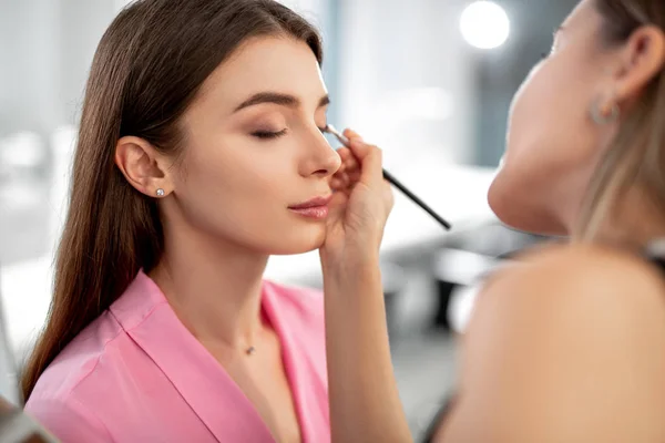 Attraktiv ung kvinna gör makeup i skönhetssalong — Stockfoto