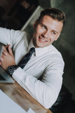 Yakışıklı gülümseyen iş adamı iş üstünde defter