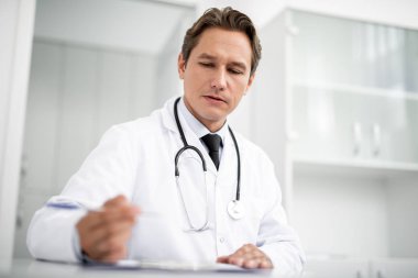 Masada oturan ve notlar sakin genç Uygulayıcı