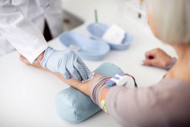 Hasta doktor cilt temizliği ve yastık üzerinde dirsek koyarak