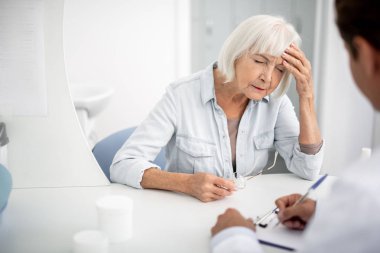Gözlerini kapatma ve baş ağrısı muzdarip yaşlı kadın