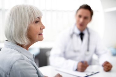 Onun pratisyen ile oturan sakin yaşında bayan, yakın çekim