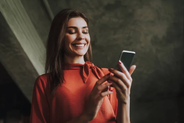 Sorrindo mulher de negócios lendo mensagens no telefone — Fotografia de Stock