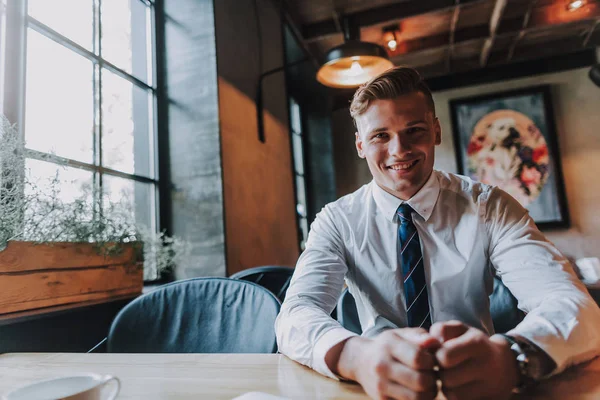 Νέοι επιτυχημένη χαμογελαστός άνθρωπος που κάθεται στο καφενείο — Φωτογραφία Αρχείου