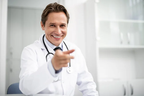 Feliz doctor sonriendo y señalando con el dedo — Foto de Stock