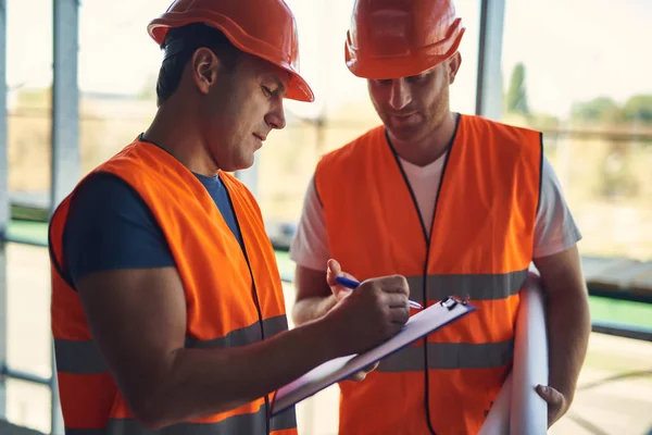 Capataz atento tomando notas y su colega buscando — Foto de Stock