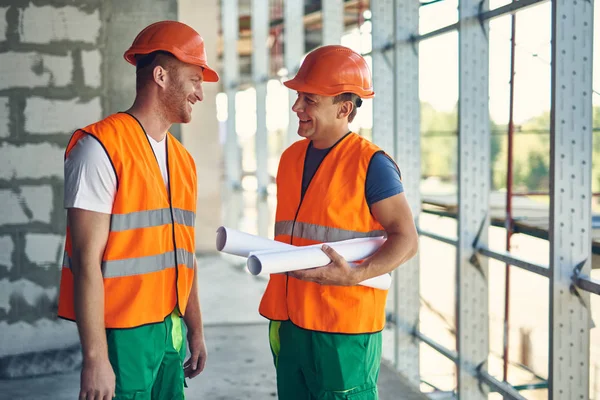 Constructeurs sympathiques souriant tout en ayant une conversation agréable — Photo