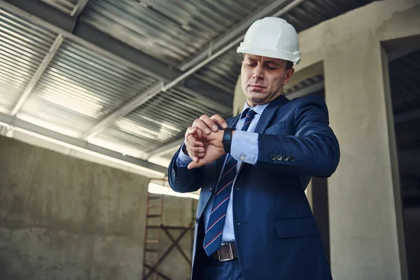 Architect in helmet standing on construction site — Stock Photo, Image