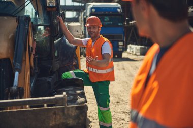 Turuncu formunda iki inşaatçılar açık duruyor