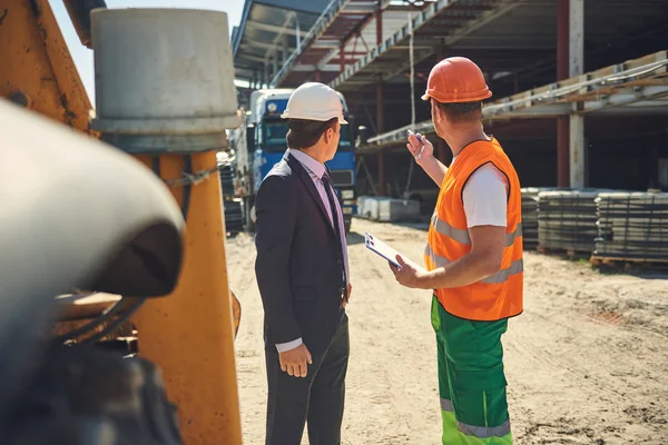 Patron avec travailleur regardent sur la construction — Photo