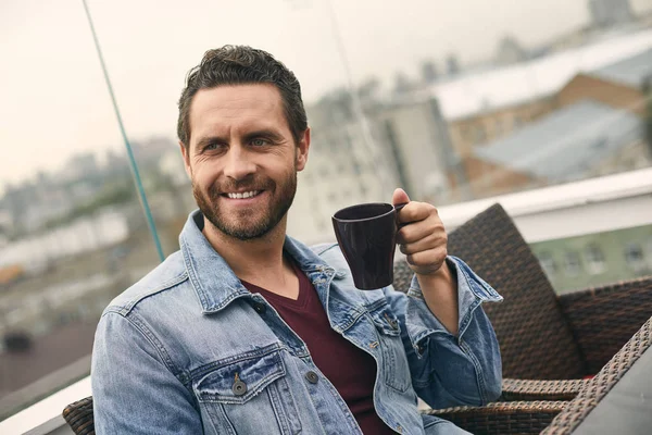 Happy man is holding cup in hand — Stock Photo, Image