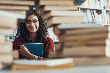Kitap tutarken sevimli kıvırcık öğrenci ifade sevinç