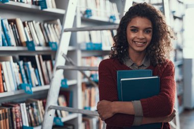 Neşeli öğrenci onun göğsüne iki kitap basarak yukarı bel