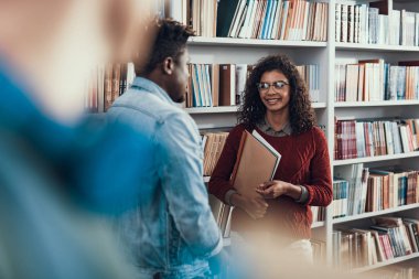 Çok kıvırcık Bayan öğrencilik için konuşurken gülümseyen