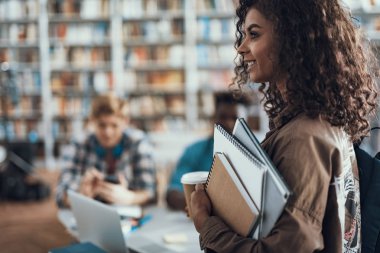 Notebook taşıma ve mesafe içine bakarak neşeli öğrenci