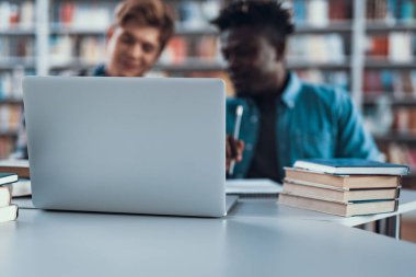 Belgili tanımlık laptop ve oturma ve konuşurken iki kişi seçici odak