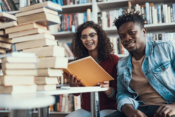 Onun arkadaşı yanında oturan ve gülümseyen Afro-Amerikan öğrenci